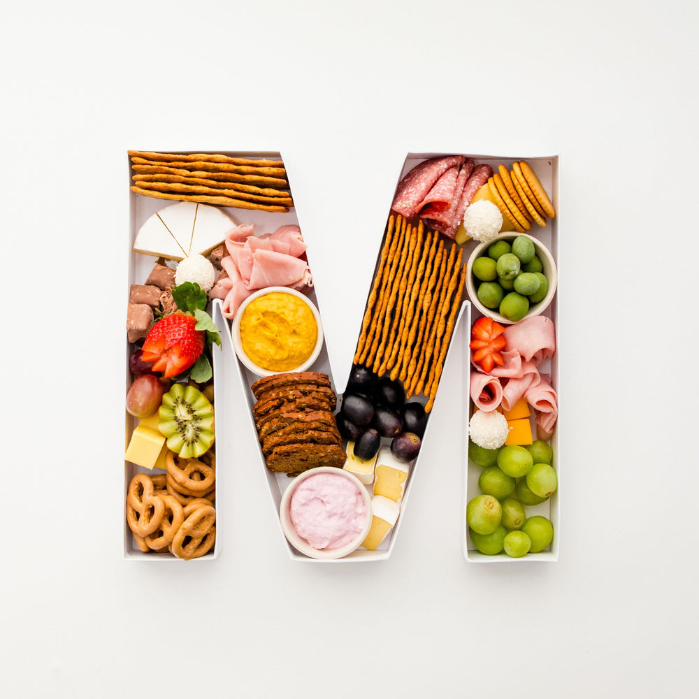 Overhead view of a charcuterie-filled letter M