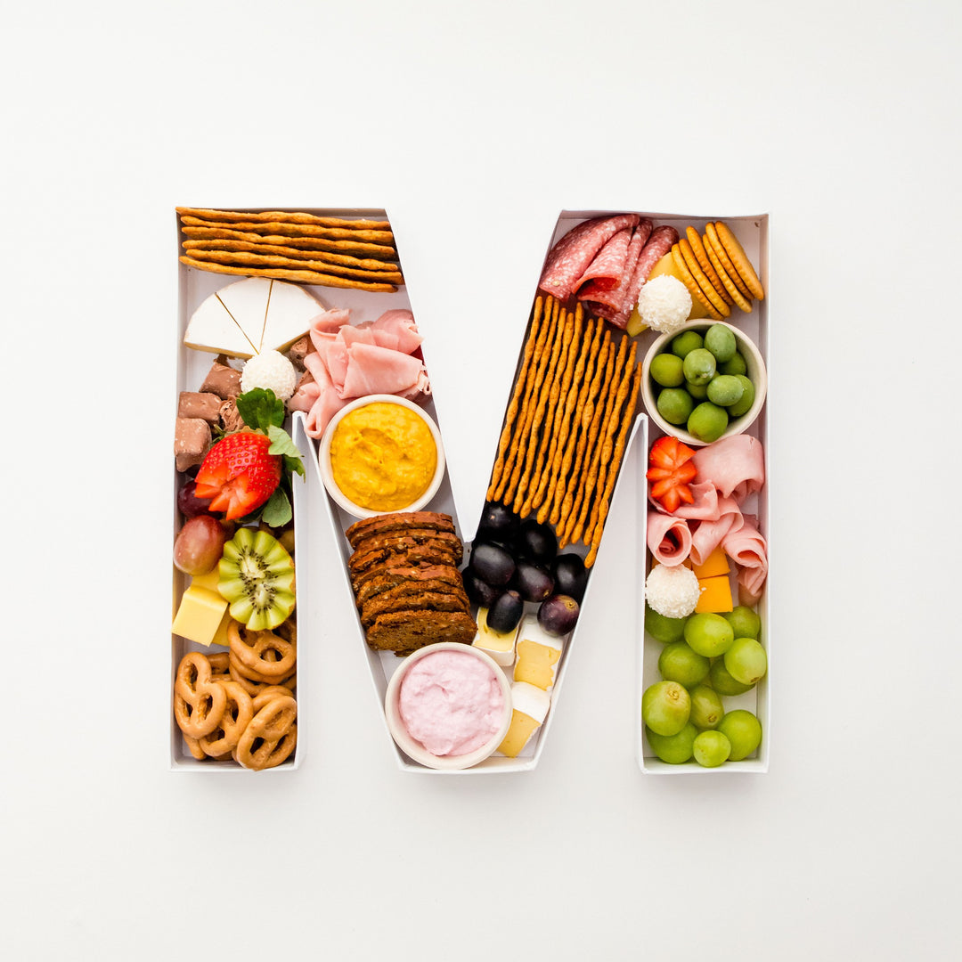 Overhead view of a charcuterie-filled letter M