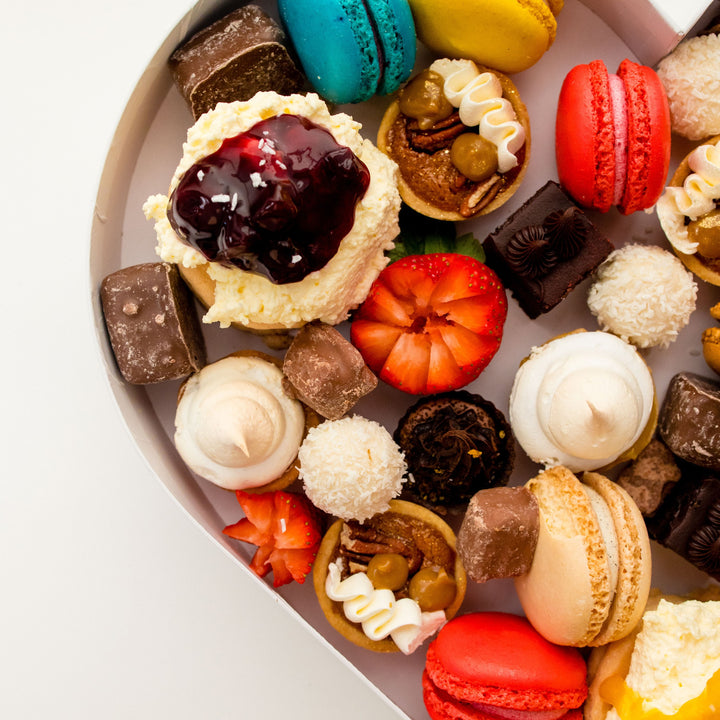 Close-up of mini desserts, macarons, chocolate treats and strawberries