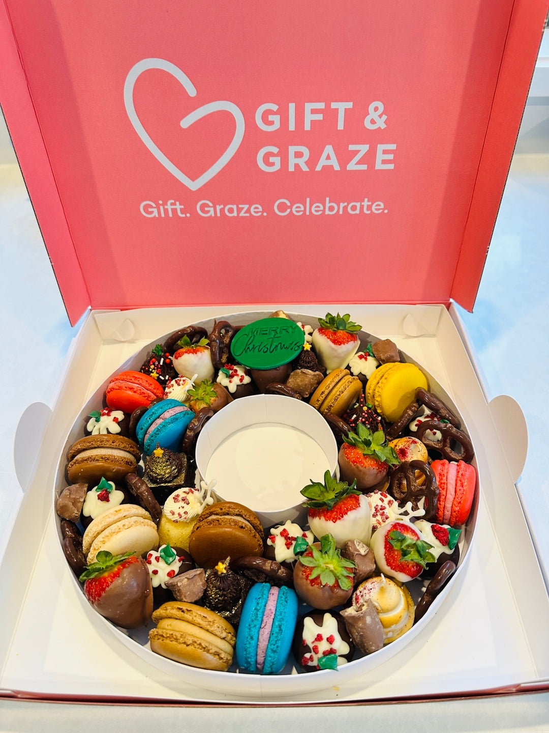 Dessert-filled letter O in a Gift & Graze display box, shown with seasonal Christmas decoration