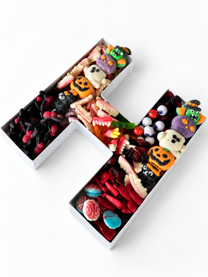 Halloween lolly-filled letter H on a clean white background